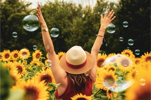 woman arms up sunflowers and bubbles